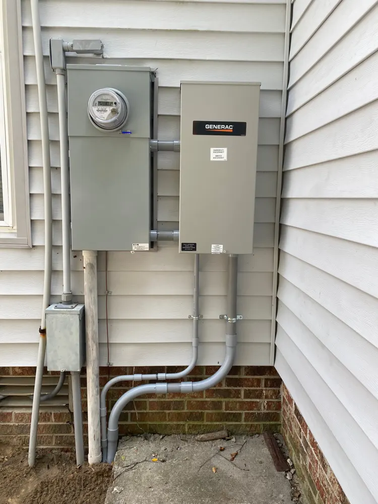 Generac automatic transfer switch mounted next to the electric meter on a house with vinyl siding