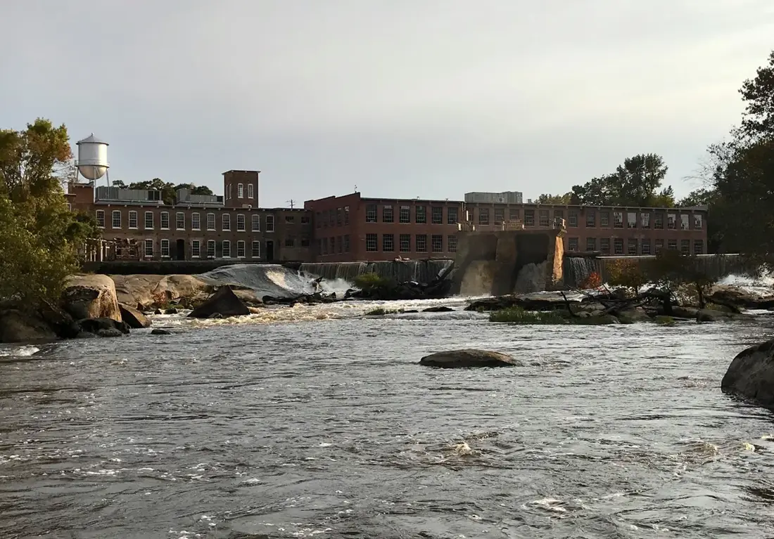 The Tar River flowing past the brick buildings of Rocky Mount Mills